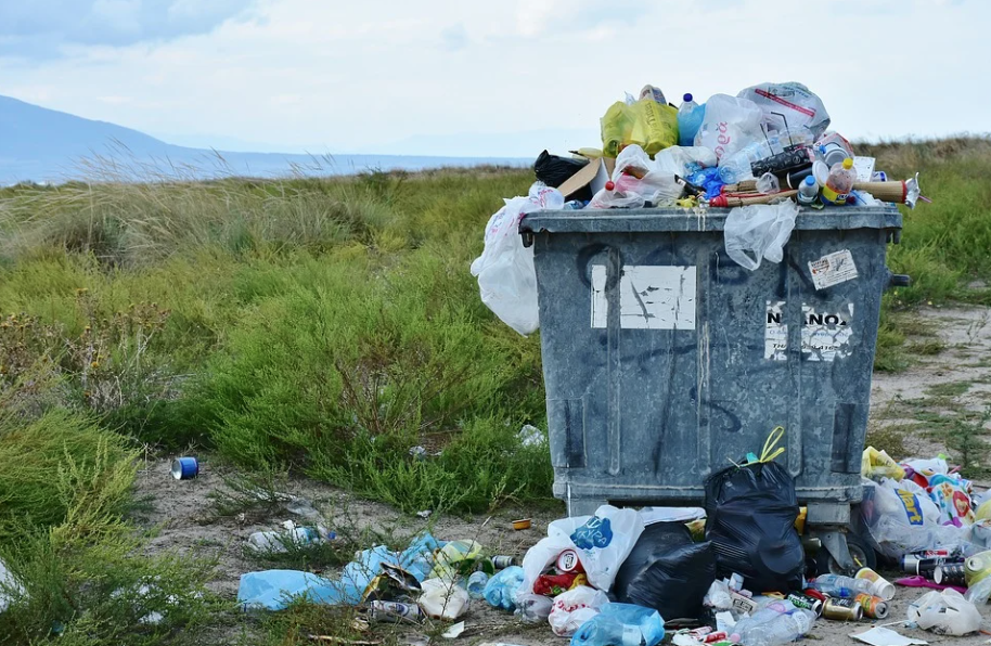 une poubelle qui déborde, signe de la pollution humaine