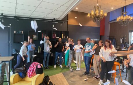 MAIF_1 séminaire avec des personnes qui lancent des avions en papier